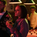 woman standing having a drink at a nightclub