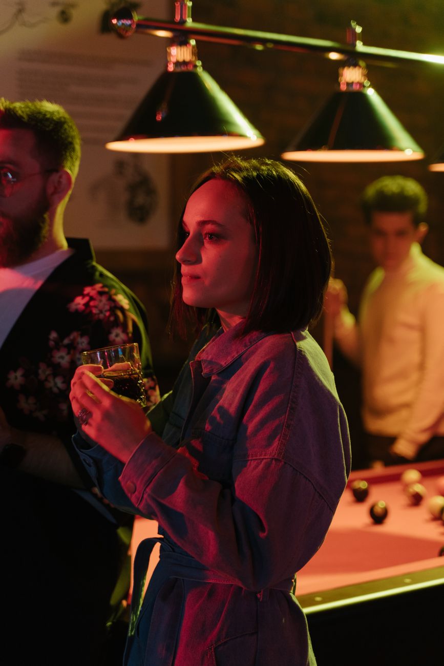 woman standing having a drink at a nightclub